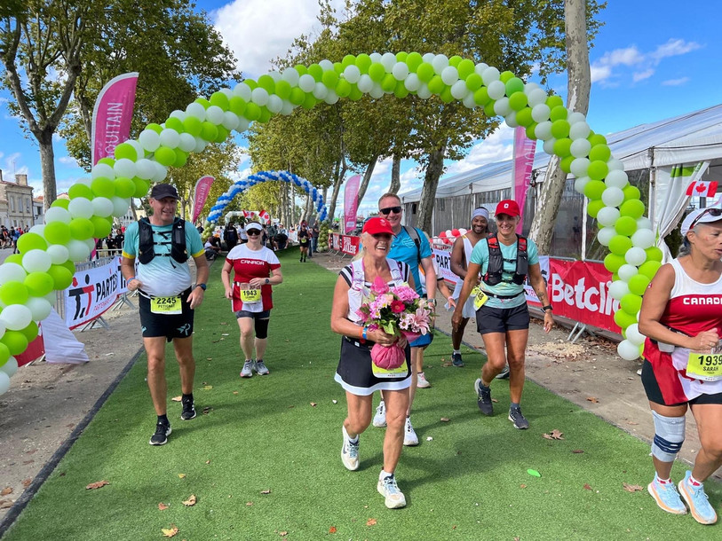 Christiane Grindu franchissant la ligne d'arrivée au Médoc, entourée de ses amis. Et de 100 ! (Photo : Raffi Kouyoumdjian)