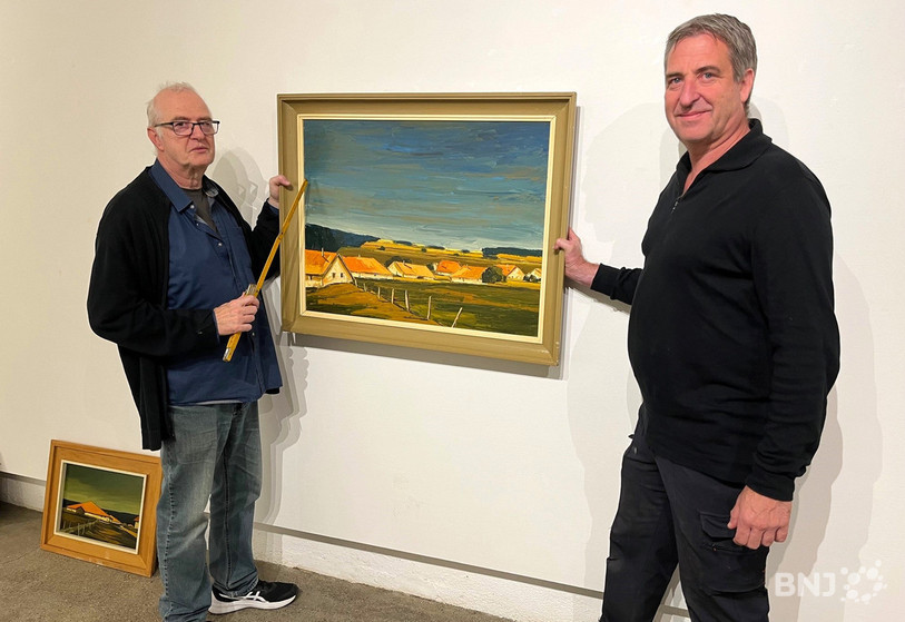 Pierre-Alain et Frédéric Michel (de gauche à droite) accrochent ici une peinture de leur père Pierre Michel, qui aurait célébré ses 100 ans en décembre prochain.