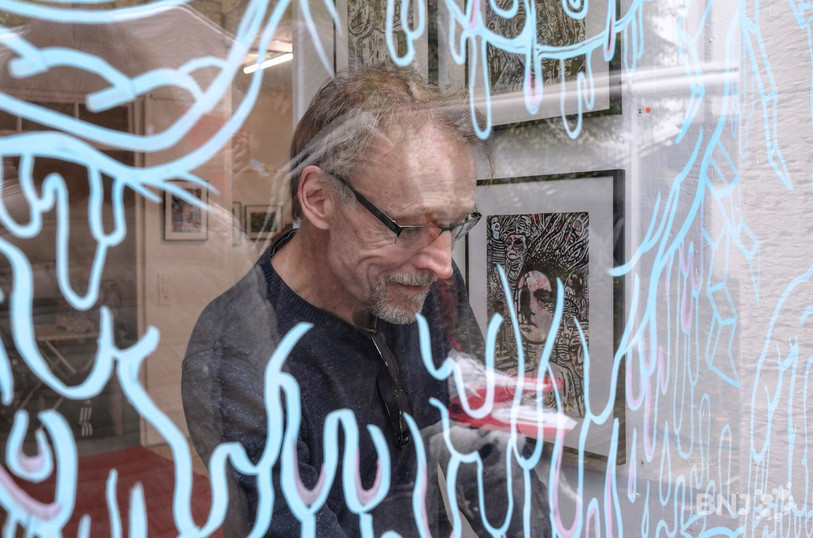 Yves Hänggi improvise un dessin sur la vitrine de la Galerie Samia Artho en vieille ville de Delémont.