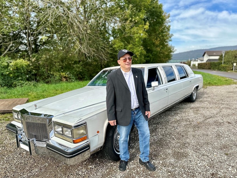 Passionné de voitures anciennes, Pascal Prince pose devant sa Cadillac Fleetwood Brougham.