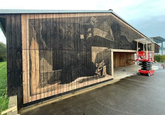 La fresque de l'artiste vaudois LPVDA orne désormais une des façades de l'école jurassienne du bois à Delémont (photo: AJECEM).