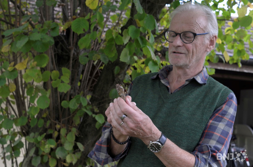 André Monnerat tient une feuille qui inspire une nouvelle photo.