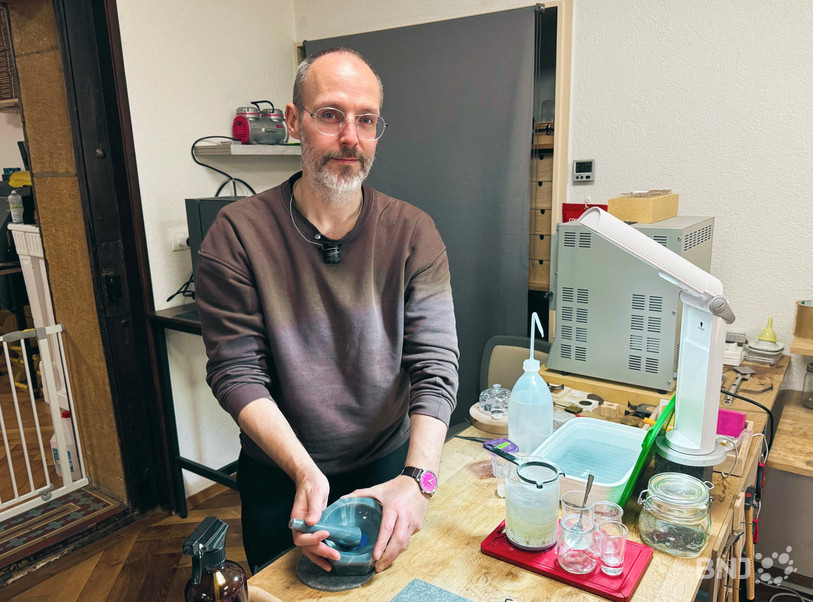 Bastien Vuilliomenet dans son atelier, avec son mortier en agate mentionné dans le reportage.