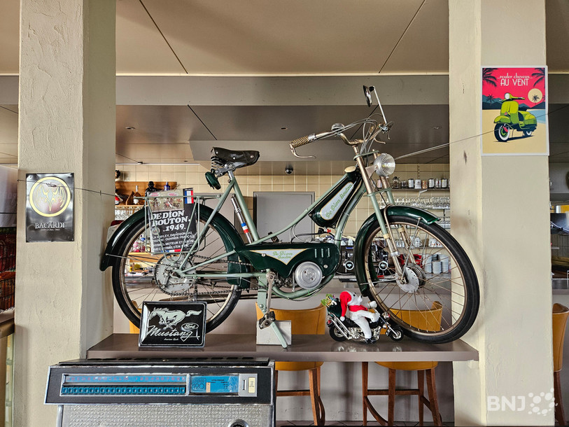 Un vélomoteur trône à proximité du bar