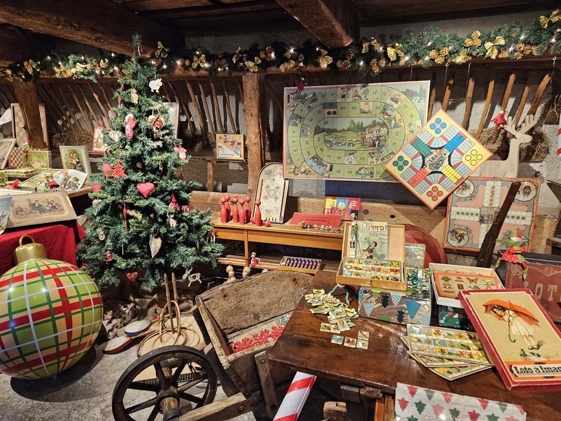 Entre sapin, guirlandes et boule de Noël sont exposés des anciens jeux de la collection du Musée paysan et artisanal.