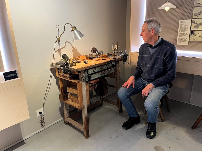 Daniel Curtit, ancien horloger réparateur au musée international d'horlogerie à La Chaux-de Fonds, assis à un établi datant du début du XIXe siècle.