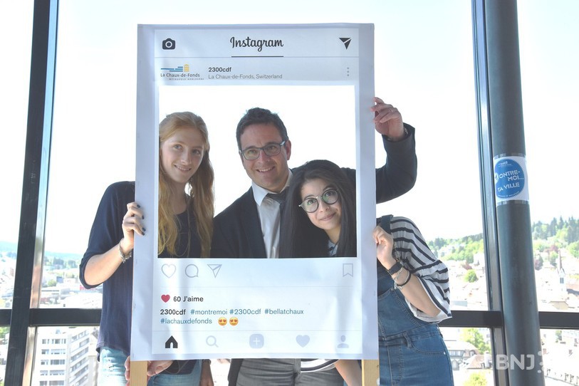 Clara Pereira Luiz et Charlène Mamie, stagiaire et employée au service de la communication entourent le président de la Ville, Théo Huguenin-Elie dans un cadre qui pourrait vous servire à immortalisé les beautés de la Métropole horlogère. 