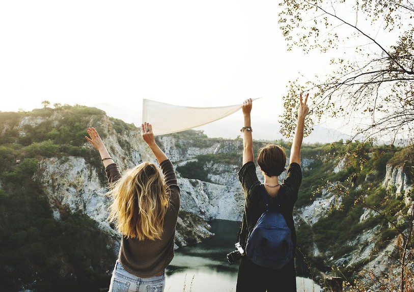 deux femmes de dos devant un paysage montagneux