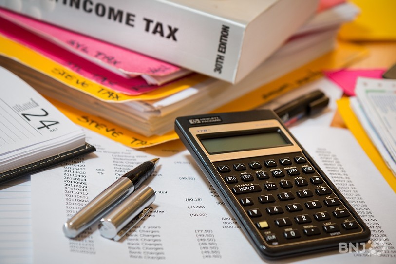 Une image d'illustration représentant des taxes ou un budget, avec une calculatrice