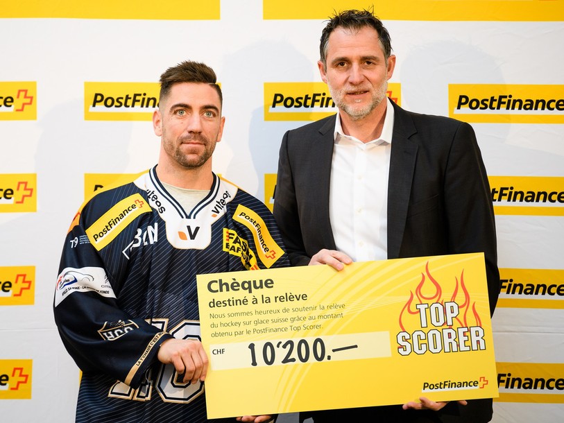 Dominic Forget (à gauche) a reçu son chèque des mains de Thomas Zimmermann, responsable de du marketing et du sponsoring chez PostFinance (photo : PPR/Manuel Lopez)