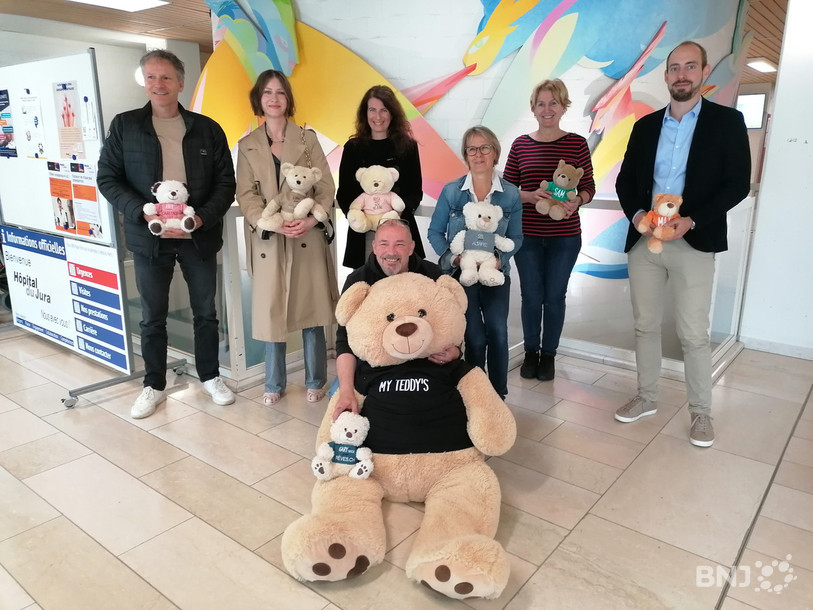 Devant, l’initiateur du projet Dominique Jayram avec la mascotte avec, à l’arrière, les différentes associations jurassiennes avec leur ourson spécifique.