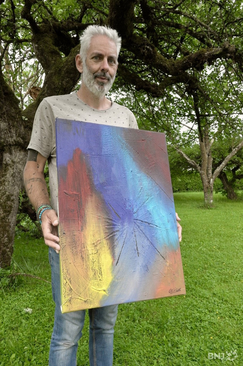 Angelo Oliva avec son oeuvre qui s'affiche pour l'évènement