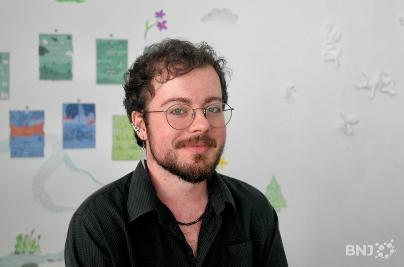 Raymond Connell devant les planches de sa BD « Ne jouez pas avec des loups affamés ».