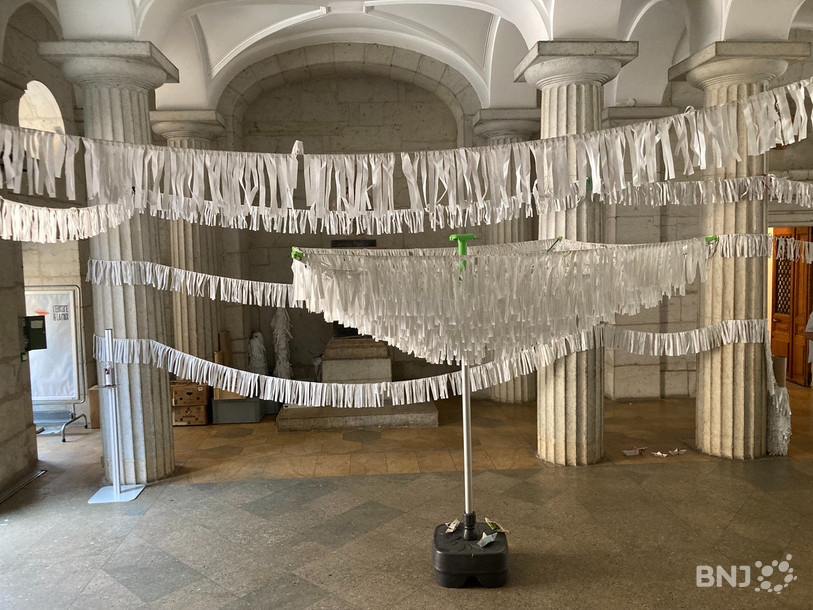 Chaque bandelette de papier représente une personne décédée sur le chemin de l'exil. Ici, une installation au Péristyle de l'Hôtel de Ville de Neuchâtel. 