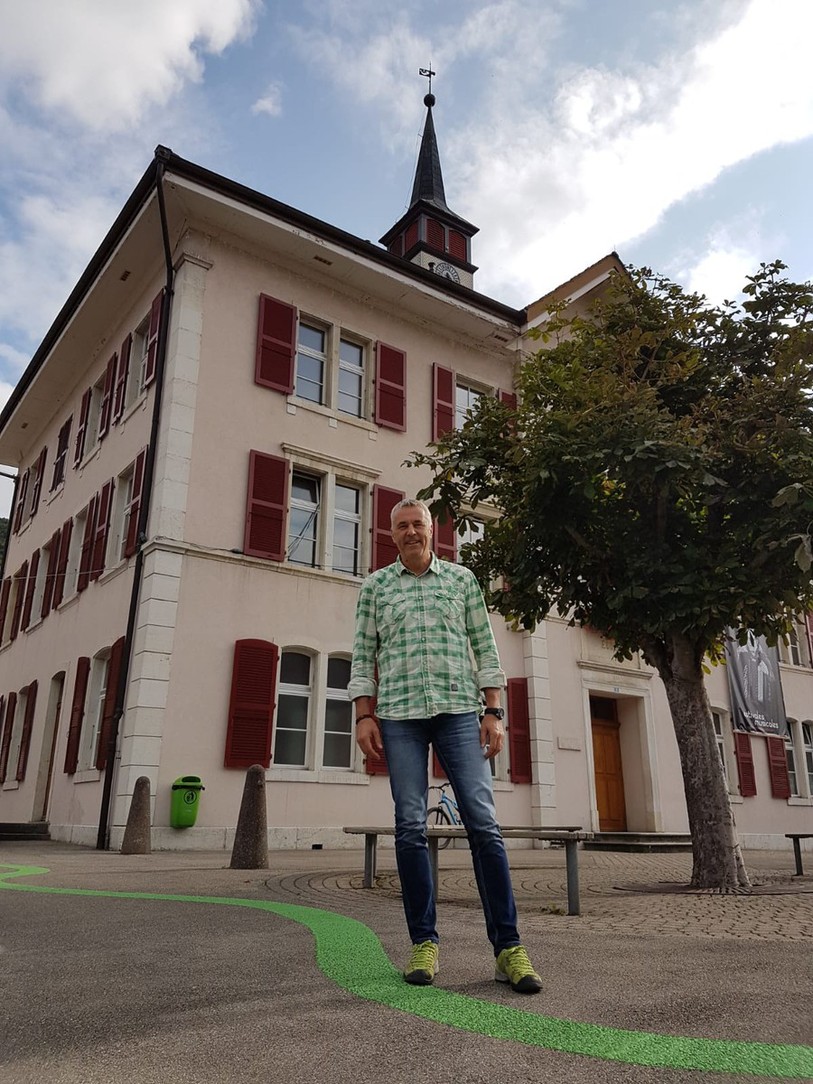 Jean-Luc Niederhauser, le maire de Court, pose devant l'école du village.