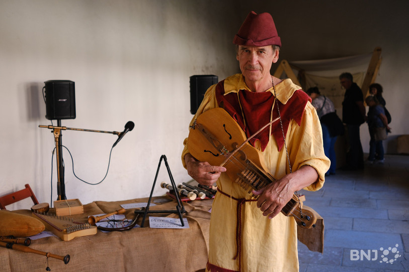 Dagobert transmet sa passion pour les instruments anciens. Ici il pose avec une moraharpa, un instrument scandinave.