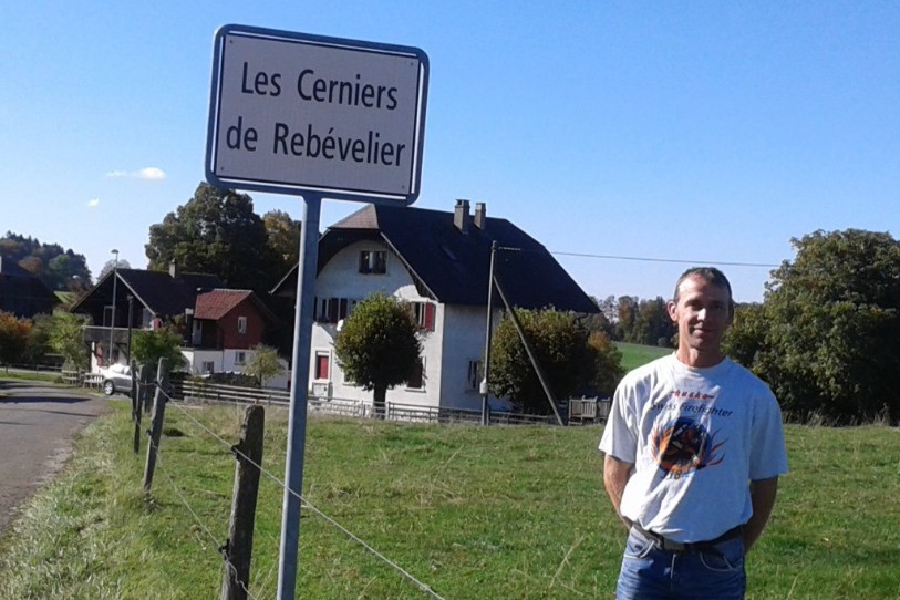 Michael Amstutz pose à l'entrée du hameau Les Cerniers de Rebévelier.