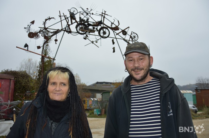 Anet (à gauche) et Olivier, deux des habitants du «  Schrottbar  » à Bienne devant le portail d'entrée du village.