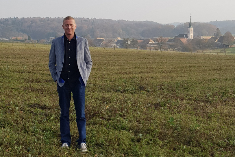 Le maire de Basse-Allaine, Daniel Ramseyer, sur une de ses parcelles avec Montignez en arrière-plan.