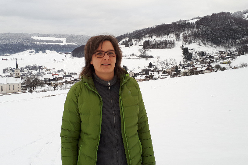 Martine Brêchet a été prise en photo avec le village de Mervelier en fond et, plus loin, celui de Montsevelier.