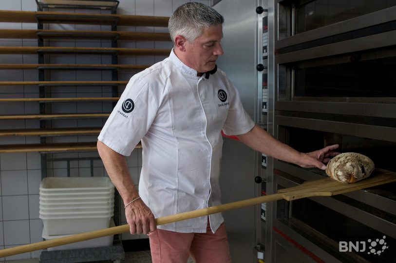 À la sortie du four, l’artisan boulanger David Parrat tapote sur le pain pour s’assurer de sa réussite.