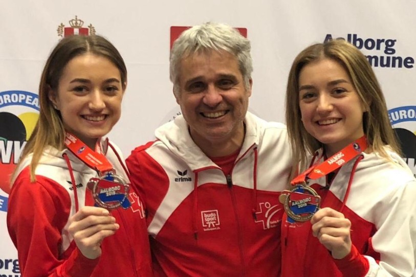 Le coach du Neuchâtel Karaté-Do Franco Pisino entouré de gauche à droite par les soeurs Amélie et Florence Voegelin.