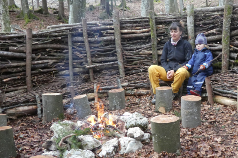 L'une des deux initiatrices du projet, Emilie Tallat, assise avec son fils sur le canapé forestier, vrai centre stratégique du groupe de jeux en forêt. (Photo: association Ô Bois)