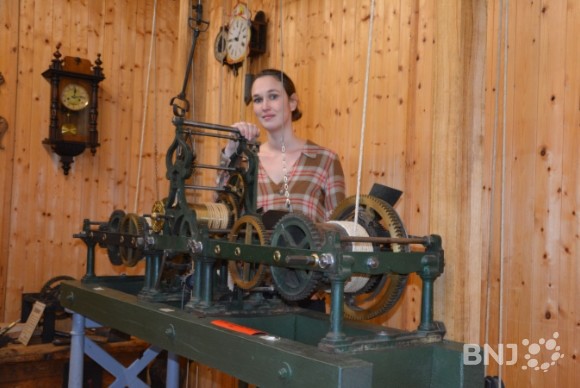 Nathalie Zürcher, derrière le mécanisme de l'ancienne horloge du clocher de l'église de Movelier, entièrement restauré par Marc Chappuis.