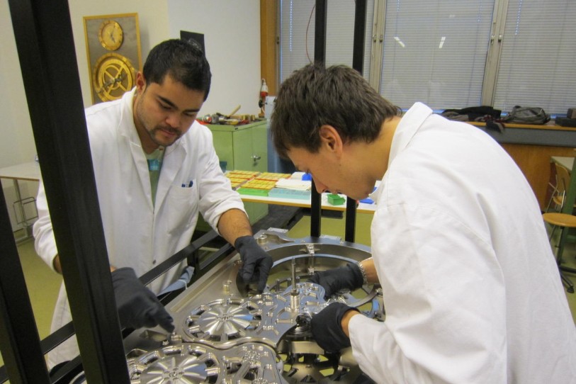 Deux apprentis de la Division technique travaillant sur le mouvement de l’horloge (photo : canton du Jura).