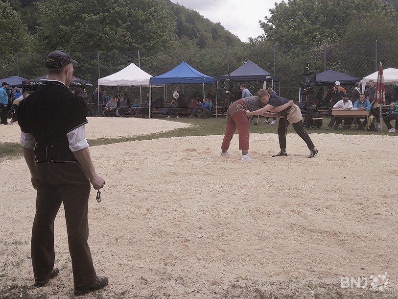 Un arbitre se tient debout et fait face à deux autres juges, assis à une table. Les décisions quant aux points marqués se prennent à trois.