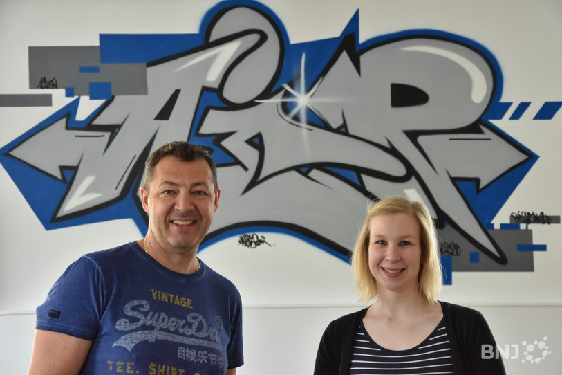Pierre-Alain Basso et Cécile Maitre, les animateurs de l'AJR, posent devant la fresque réalisée par les jeunes avec l'aide de l'association Face au mur. 