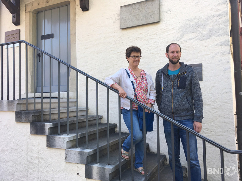 Christine Steiner, guide bénévole (à gauche), et Régis Froidevaux, président de l’Association des guides touristiques de Delémont et environs (à droite), posent devant la Maison Wicka. 