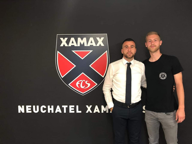 Léo Farine (à droite) pose fièrement devant l'écusson de Neuchâtel Xamax FCS.