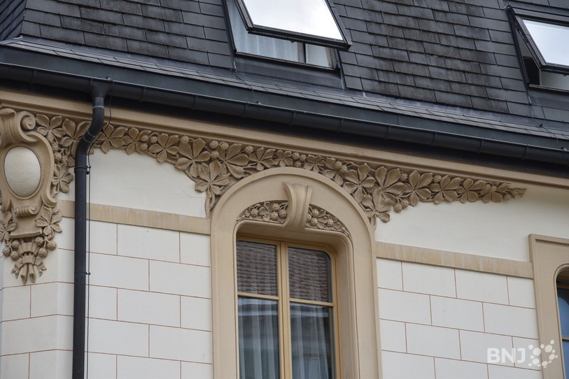 Les tours de fenêtres sont décorés de feuilles de maronniers, typiques de l'Art Nouveau.