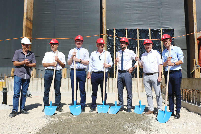 Ils s’y sont mis à six pour recouvrir la première pierre, munis d'un casque rouge. De gauche à droite : Gérard Meyer (président du comité de pilotage), Gabriel Voirol (maire de Porrentruy), Stéphane Babey (président du SIDP, le syndicat intercommunal du district de Porrentruy), Martial Courtet (ministre en charge des sports), Claude Hêche (président du comité de soutien) et Matthias Remund (directeur de l’Office fédéral des sports), accompagnés tout à gauche par Grégory Pressacco (responsable technique du SIDP).