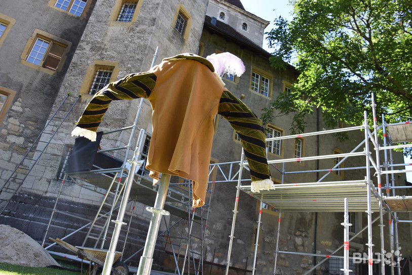 Le décor représente un chantier moderne qui contraste avec le château.