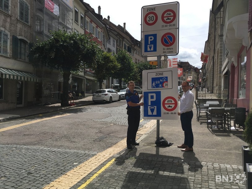 Dominique Vallat, commissaire à Porrentruy et Julien Loichat, conseiller municipal, présentent l'un des nouveaux panneaux de la zone de rencontre en vieille ville.