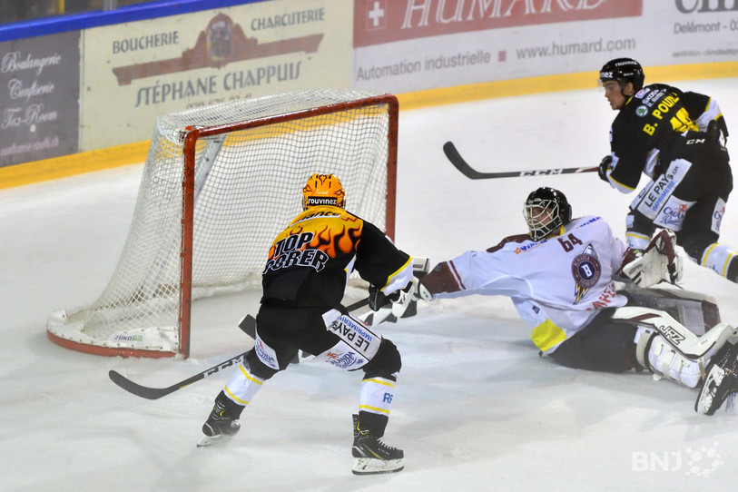 La scène de la victoire: Le Top Scorer ajoulot Philip-Michael Devos (casque jaune) exploite l'offrande de Bastien Pouilly pour battre le gardien tessinois Beat Trudel et offrir deux points au HCA (photos: Georges Henz).
