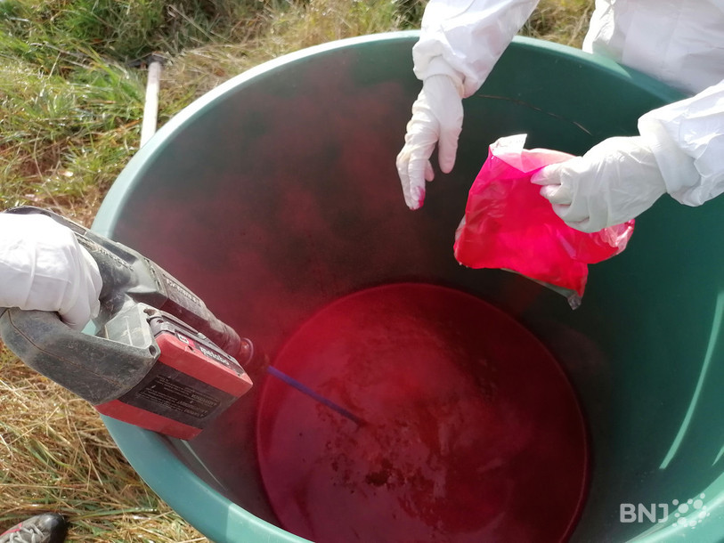 Un colorant est dilué dans un grand récipient, avant d’être injecté dans le sol.
