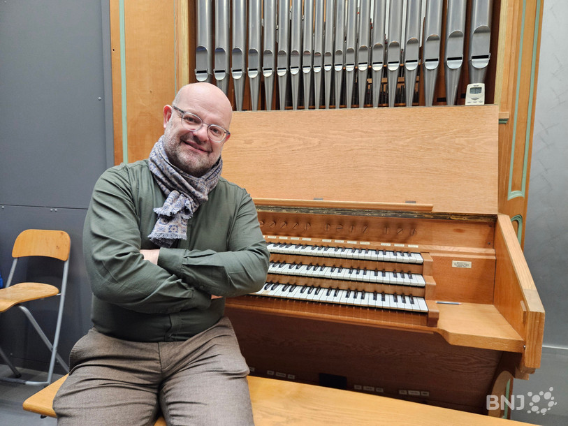 Nicolas Farine, directeur du Conservatoire de musique neuchâtelois, assis sur le banc d'un orgue reçu en don au début des années 2000 par Marie Dufour.
