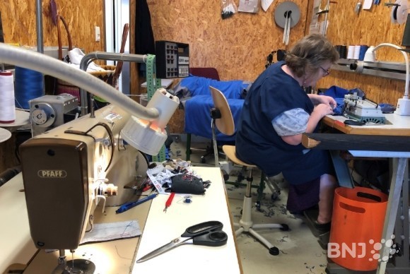 Trois couturières et un couturier travaillent sur le site de Bonfol.