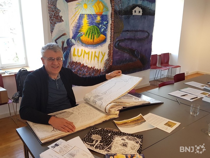 Darko Vulic pose devant ses écrits et ses illustrations.