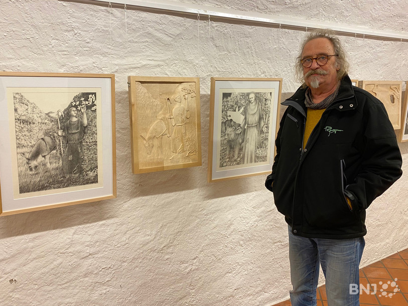 L'artiste de St-Ursanne Michel Marchand pose parmi les œuvres de « Vie et légendes illustrées d’Ursanne ».