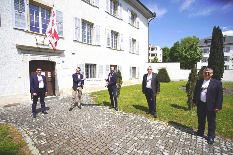 Le président du Gouvernement jurassien Martial Courtet reçoit le chèque des quatre présidents régionaux des Banques Raiffeisen (photo ldd).