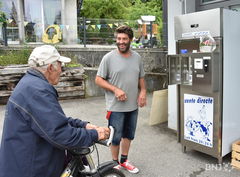 Raphaël Dupasquier devant le distributeur avec le tout premier client.