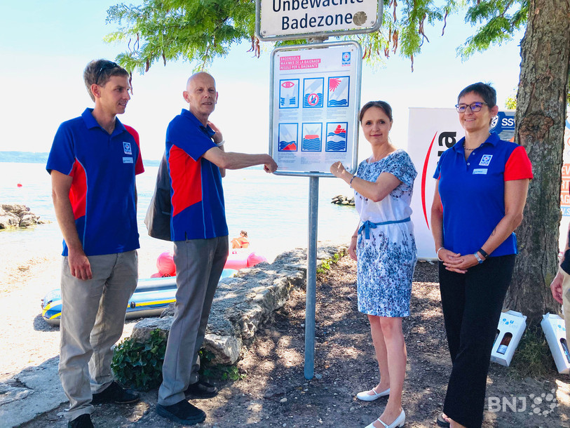 Daniel Koch, Violaine-Blétry de Montmollin et les membre de la Société suisse de sauvetage ont installé un panneau de prévention sur la plage des Jeunes Rives à Neuchâtel. 