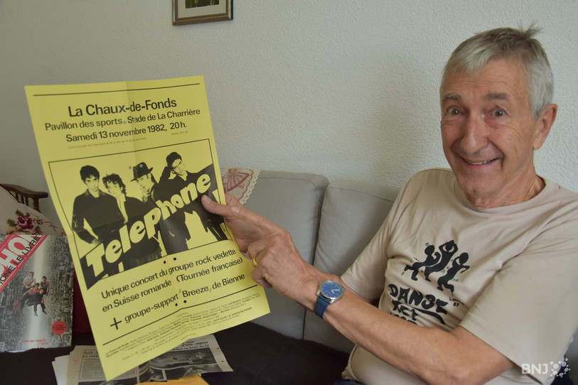 Jacques Frey avec l'affiche du concert de Téléphone, qui avait eu lieu en 1982 au Pavillon des sports à La Chaux-de-Fonds. (Photo : archives)