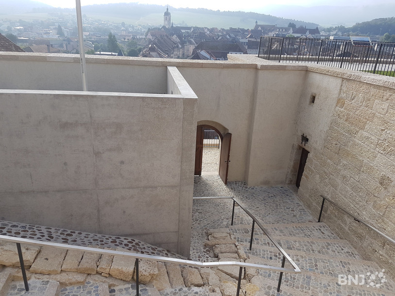 Le chemin d'accès historique au château a été restauré, on remarque en bas à droite la porte menant au local médiéval qui servait de poste de garde, puis de prison.