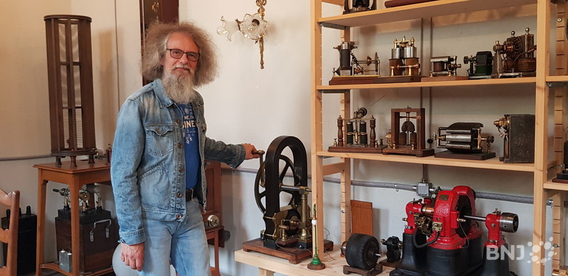 Georges Cattin pose devant une dynamo de laboratoire. 