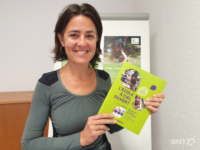 Muriel Morand Pilot, porte-parole de la section romande de Silviva, tient dans ses mains le manuel « L’école à ciel ouvert ». Il contient des idées d'enseignement dans la nature pour toutes les matières du 1er et du 2e cycle de l'école primaire.